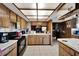 Kitchen with wood cabinets, a center island, and black appliances at 11109 Sumner Rd, Wimauma, FL 33598
