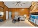 Living room with wood paneling, ceiling fan, and stone fireplace at 11109 Sumner Rd, Wimauma, FL 33598