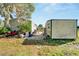 Manufactured home with a storage shed and overgrown yard at 11109 Sumner Rd, Wimauma, FL 33598