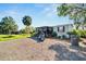 Single-wide manufactured home with covered porch and gravel driveway at 11109 Sumner Rd, Wimauma, FL 33598
