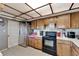 Kitchen with wood cabinets, black appliances, and a tiled floor at 11109 Sumner Rd, Wimauma, FL 33598