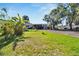 Single-wide manufactured home with a large grassy yard and tropical plants at 11109 Sumner Rd, Wimauma, FL 33598