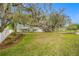 House with a large front yard, mature trees, and a long driveway at 10502 Tarpon Springs Rd, Odessa, FL 33556