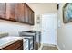 Bright laundry room with washer, dryer, cabinets, and granite countertop at 2727 Colewood Ln, Dover, FL 33527