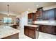 Island kitchen with dark wood cabinets, granite countertops, and stainless steel appliances at 2727 Colewood Ln, Dover, FL 33527