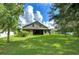 Large backyard with lush green grass and mature trees at 2727 Colewood Ln, Dover, FL 33527