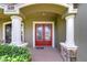Elegant front entry with a red double door, arched entryway, and white columns at 2727 Colewood Ln, Dover, FL 33527