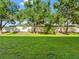 Green backyard features grass, trees, and white privacy fence at 12820 Belvedere Song Way, Riverview, FL 33578