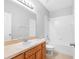 Bathroom featuring a wood cabinet with sink, a big mirror, a toilet and a bathtub at 12820 Belvedere Song Way, Riverview, FL 33578