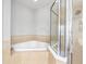 Bright bathroom showcasing a corner bathtub and tiled shower with glass enclosure at 12820 Belvedere Song Way, Riverview, FL 33578