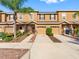 Exterior view of townhomes featuring two-car garages, neutral paint, and well-maintained landscaping at 12820 Belvedere Song Way, Riverview, FL 33578