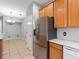 Well-equipped kitchen featuring stainless steel refrigerator and matching cabinets with open view into dining room at 12820 Belvedere Song Way, Riverview, FL 33578