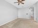 Neutral toned living room showcasing ceiling fan and light filled adjacent rooms at 12820 Belvedere Song Way, Riverview, FL 33578
