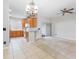 Open-concept living room and kitchen area featuring carpeted floors, tile floors, and modern lighting at 12820 Belvedere Song Way, Riverview, FL 33578