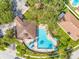 Aerial view of a community pool surrounded by palm trees, lounge chairs, and tables with umbrellas at 12820 Belvedere Song Way, Riverview, FL 33578