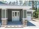 Welcoming front porch with decorative door and stone-clad pillars at 4729 Majestic Hills Loop, Brooksville, FL 34601