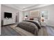 Serene main bedroom boasts plush carpeting, modern furniture, neutral tones, and ample natural light from large windows at 4729 Majestic Hills Loop, Brooksville, FL 34601
