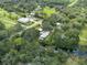 Aerial view of home, detached garage, and surrounding trees and waterway at 12805 Flint Creek Rd, Thonotosassa, FL 33592