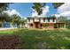 Two-story home exterior with a large covered porch and a spacious yard at 12805 Flint Creek Rd, Thonotosassa, FL 33592