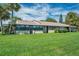 Condo's rear exterior, showcasing a spacious yard and landscaping at 1308 13Th Se Cir, Largo, FL 33771