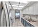 Efficient galley kitchen, featuring updated cabinetry and stainless steel sink at 1308 13Th Se Cir, Largo, FL 33771