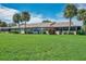Back of house with lush green lawn at 1308 13Th Se Cir, Largo, FL 33771