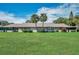 View of the back of the house and grassy backyard at 1308 13Th Se Cir, Largo, FL 33771