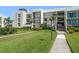 Exterior of condo building with lush landscaping and walkway at 50 Coe Rd # 322, Belleair, FL 33756
