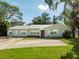 House exterior showcasing a ranch-style home with a red door and large yard at 4104 W El Prado Blvd, Tampa, FL 33629