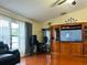 Living room features hardwood floors, a sectional sofa and an entertainment center at 2002 Sheffield Ct, Oldsmar, FL 34677