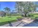 Landscaped backyard with lush greenery and large oak tree at 5333 Cobblestone Ct, Wesley Chapel, FL 33543