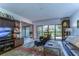 Comfortable living room with a large TV, leather furniture, and backyard access at 5333 Cobblestone Ct, Wesley Chapel, FL 33543