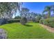 Landscaped backyard with lush green grass and mature trees at 5333 Cobblestone Ct, Wesley Chapel, FL 33543