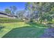 Landscaped backyard with lush green lawn and mature trees at 5333 Cobblestone Ct, Wesley Chapel, FL 33543