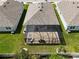 Aerial view of a home featuring a screened-in lanai and fenced yard at 1523 Glen Grove Loop, Wesley Chapel, FL 33543