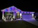 Festive home exterior illuminated with vibrant holiday lighting and manicured landscaping at 1523 Glen Grove Loop, Wesley Chapel, FL 33543