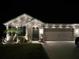 Charming single-story home features manicured landscaping and a well-lit exterior with a two-car garage at 1523 Glen Grove Loop, Wesley Chapel, FL 33543