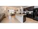 Open-concept kitchen features a large island with granite countertops and black appliances at 1523 Glen Grove Loop, Wesley Chapel, FL 33543