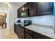 Contemporary kitchen with granite countertops, dark cabinets, and stainless-steel appliances at 1523 Glen Grove Loop, Wesley Chapel, FL 33543