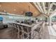 Open bar with granite counters, multiple chairs, and TVs, opening to an outdoor patio area at 4880 Hickory Oak Dr, Brooksville, FL 34601