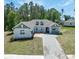 Charming single-story home boasts a manicured lawn and welcoming entrance with a lovely stone driveway at 4880 Hickory Oak Dr, Brooksville, FL 34601