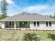 A serene view of the home's rear exterior with a covered patio, perfect for outdoor enjoyment at 4880 Hickory Oak Dr, Brooksville, FL 34601