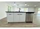 Modern kitchen island with stainless steel dishwasher and black countertop at 9085 Dorsey St, Spring Hill, FL 34608