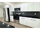 Modern kitchen with stainless steel appliances and black herringbone backsplash at 9085 Dorsey St, Spring Hill, FL 34608