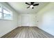 Bright bedroom with ceiling fan, closet, and wood-look floors at 9085 Dorsey St, Spring Hill, FL 34608