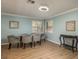 Dining area with glass table, gray chairs, and wood floors at 1500 Mahogany Ln # 605, Palm Harbor, FL 34683