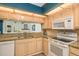 Kitchen with light wood cabinets, granite countertops, and white appliances at 1500 Mahogany Ln # 605, Palm Harbor, FL 34683
