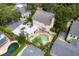 Aerial view of a home with a pool, a spacious yard, and surrounding neighborhood greenery at 1229 S Roxmere Rd, Tampa, FL 33629