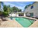 Backyard pool and patio area surrounded by a lush yard with privacy provided by hedges at 1229 S Roxmere Rd, Tampa, FL 33629