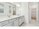 Bathroom featuring double sinks, quartz countertops, and a large mirror with modern lighting at 13730 Evergreen Valley Dr, Riverview, FL 33578